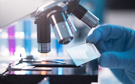 A scientist placing a slide under a microscope